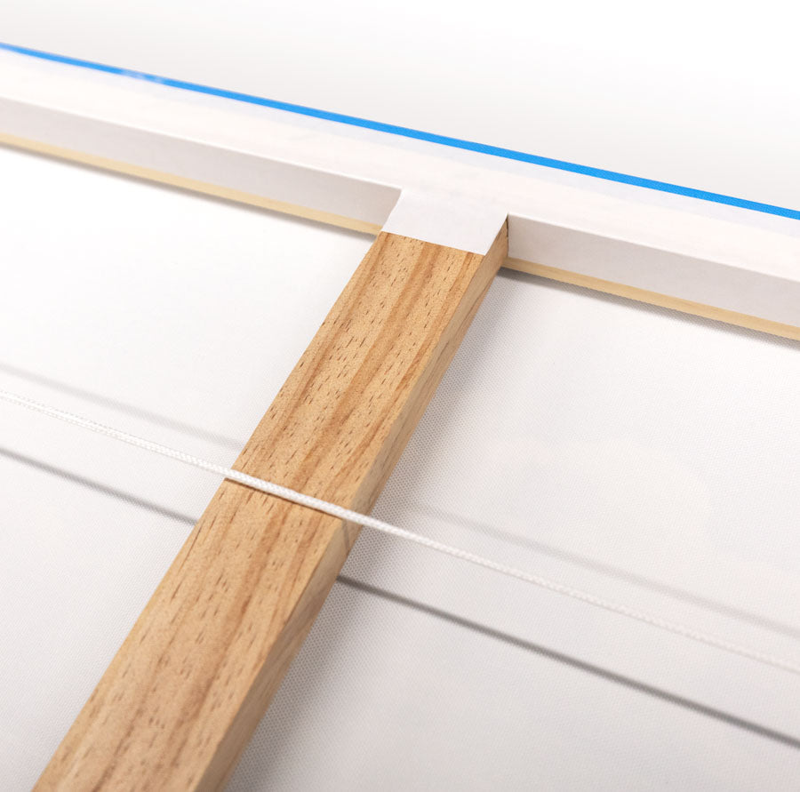 Closeup photo of back of a stretched canvas print showing the hanging cord and bracing timber