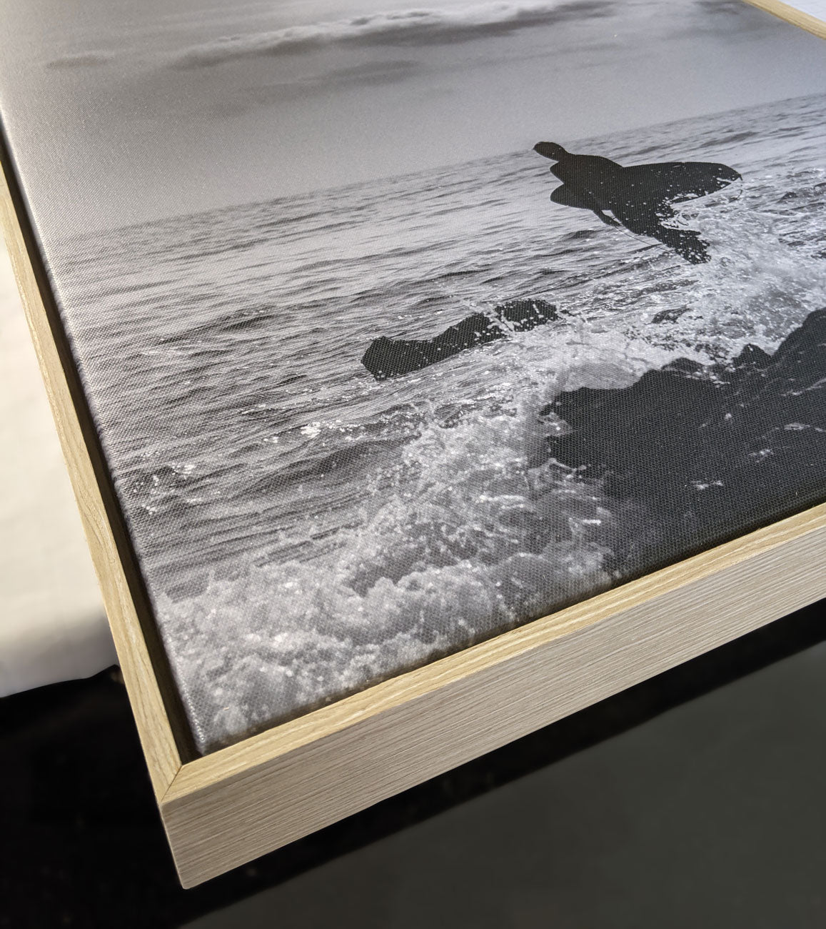 Closeup photo of black and white canvas print with oak float frame